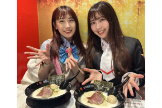 Two smiling women pose with bowls of ramen, showing beef slices and eggs in a colorful restaurant setting.